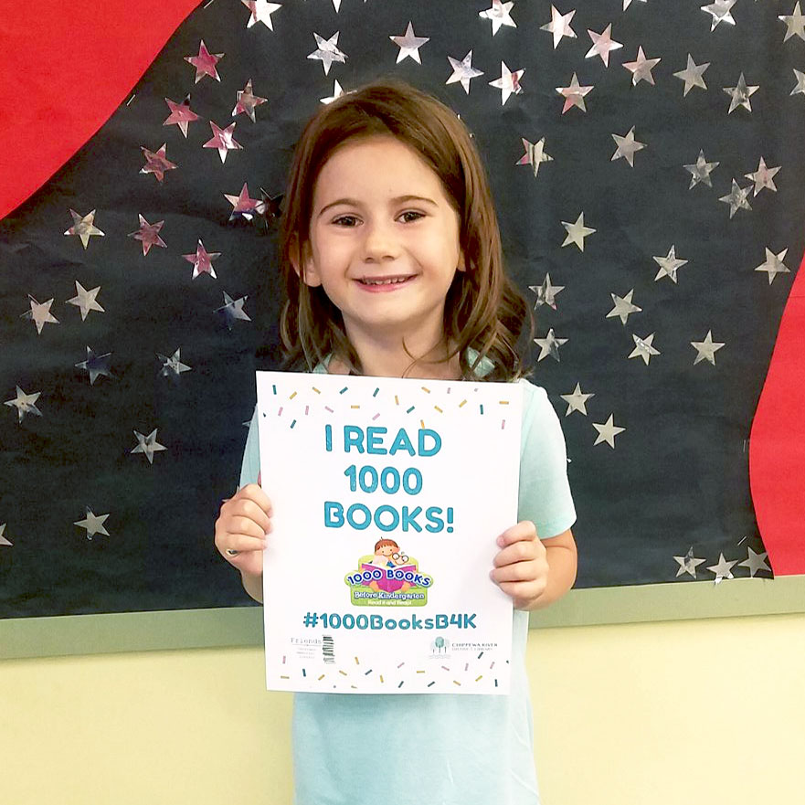 Young girl holding "I read 1000 books sign."