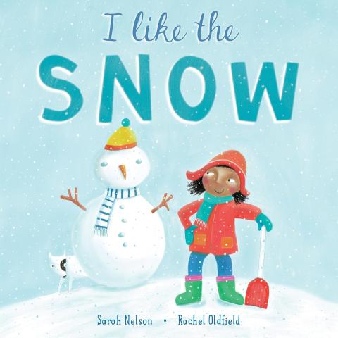 This is an illustration of a girl dressed in a winter coat, hat, mittens, and boots holding a snow shovel. She is looking at a snowman with twig arms wearing a hat and scarf. A white dog with a black eye circle is peeking out from behind the snowman. "I Like the Snow."circle is peeking out from behind the snowman.