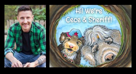 This is an image of a man sitting in the woods, wearing a green and black plaid shirt unbuttoned over a black T-shirt. Next to him is an illustrated book with two dogs looking into a hole called "Hi, We're Cece and Sherrif." him is an illustrated book with two dogs looking into a hole, called "Hi, We're Cece and Sherrif"