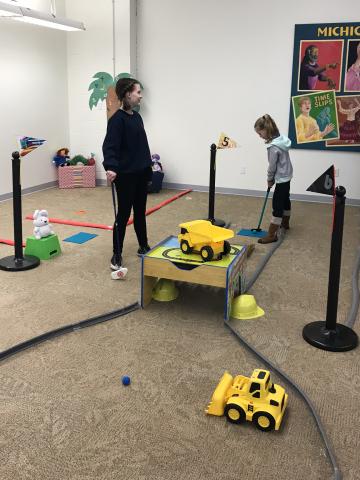 Image of children playing indoor mini golf.