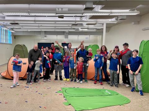 Image of a group of adults and children playing NERF.