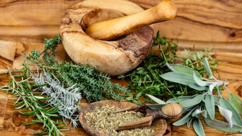 Image of a mortar and pestle with dried herbs.