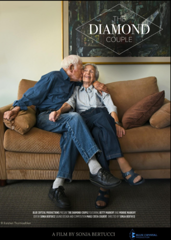 The Diamond Couple movie cover art with a couple sitting on a couch the man kissing the woman's smiling cheek.