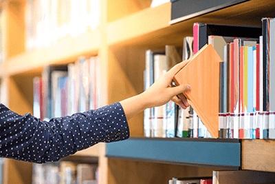 Image of a hand removing a book from a shlef.