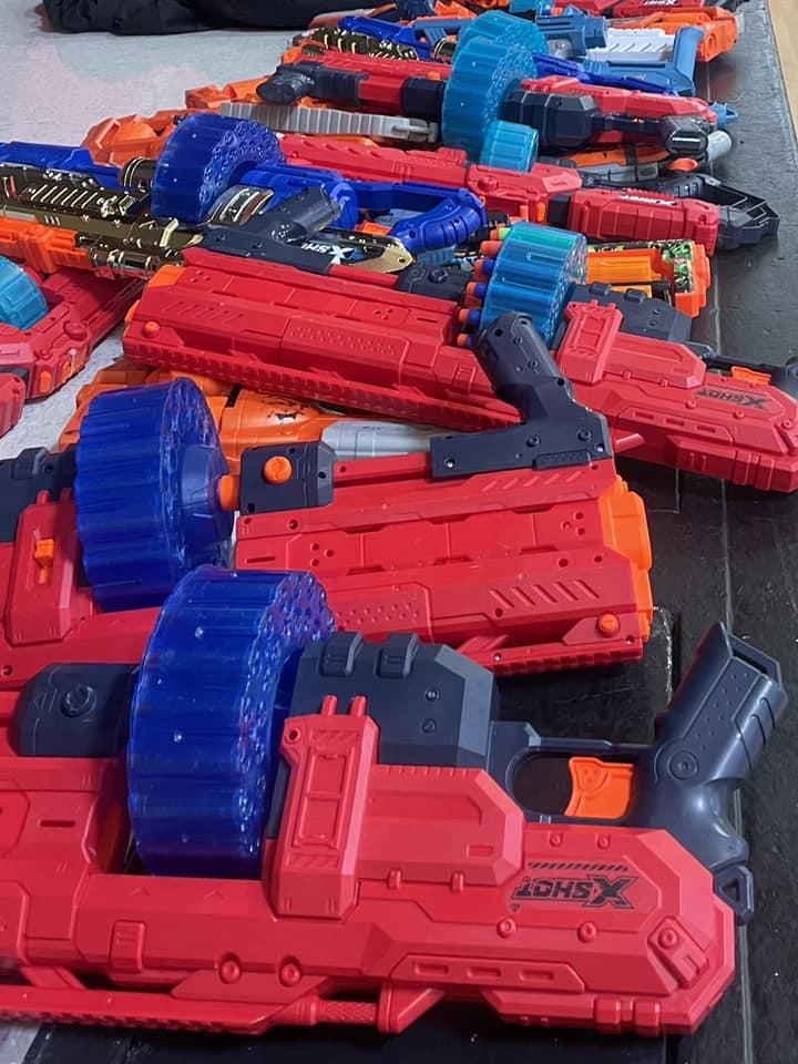 An image of red and blue NERF guns laid out on a table.