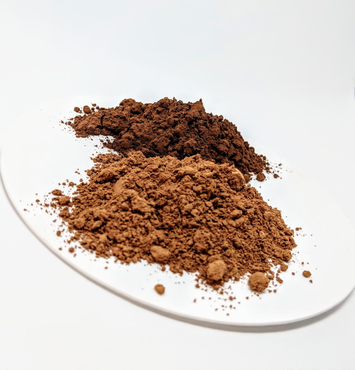 Image of non-alkalized cocoa powder in a pile on a white plate. 